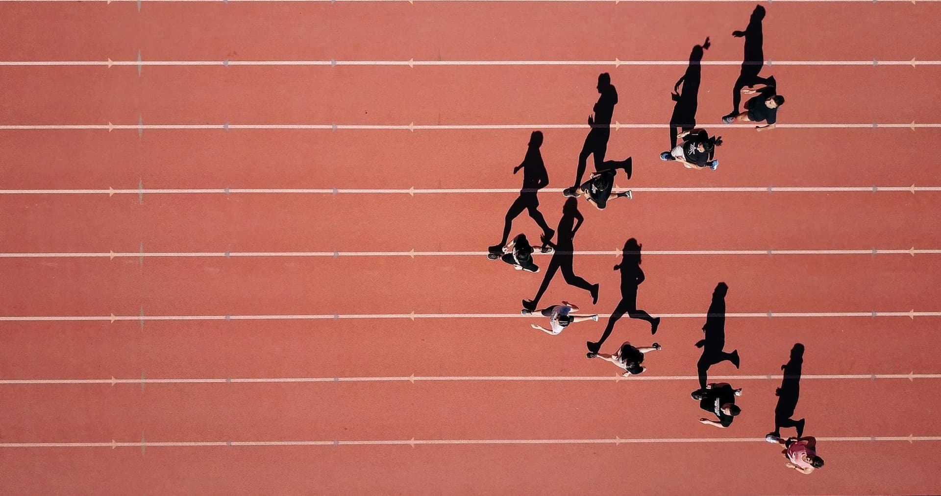 Runners spaced across a running track, seen from above