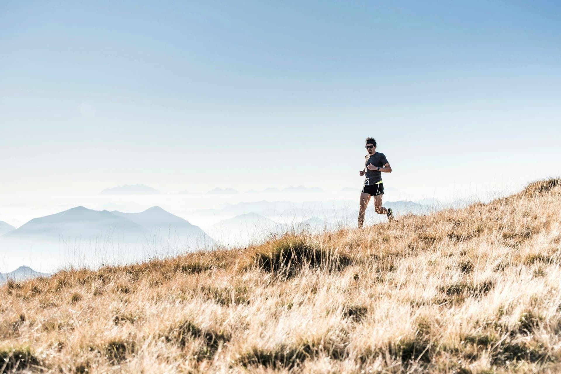 Runner on a golden hillside trail at first light
